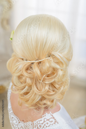 Bride's hairstyle close up. A girl in a white dress preparing for a wedding ceremony. 
