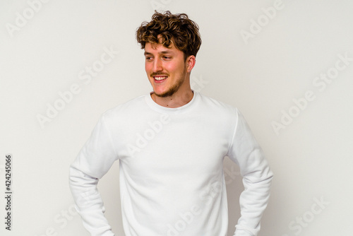 Young caucasian man isolated on white background confident keeping hands on hips.