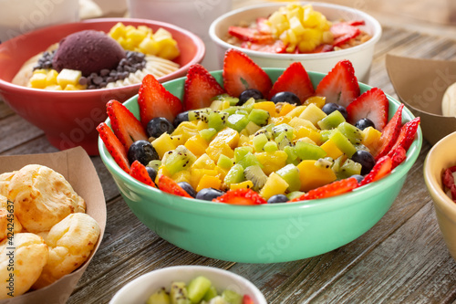 A view of a large fruit bowl, among other delicious sweet and savory sides found in a Brazilian cafe.