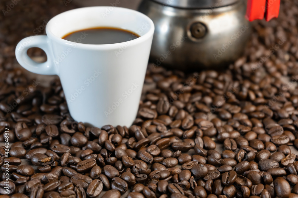 Fototapeta premium Coffee beans with american large coffee cup and moka pot.Concept Italian coffee maker background.