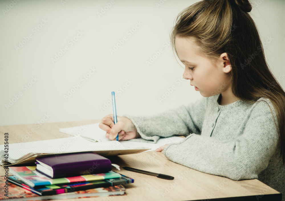 teen girl writing at the table on a white background teen girl writing at the table on a white background