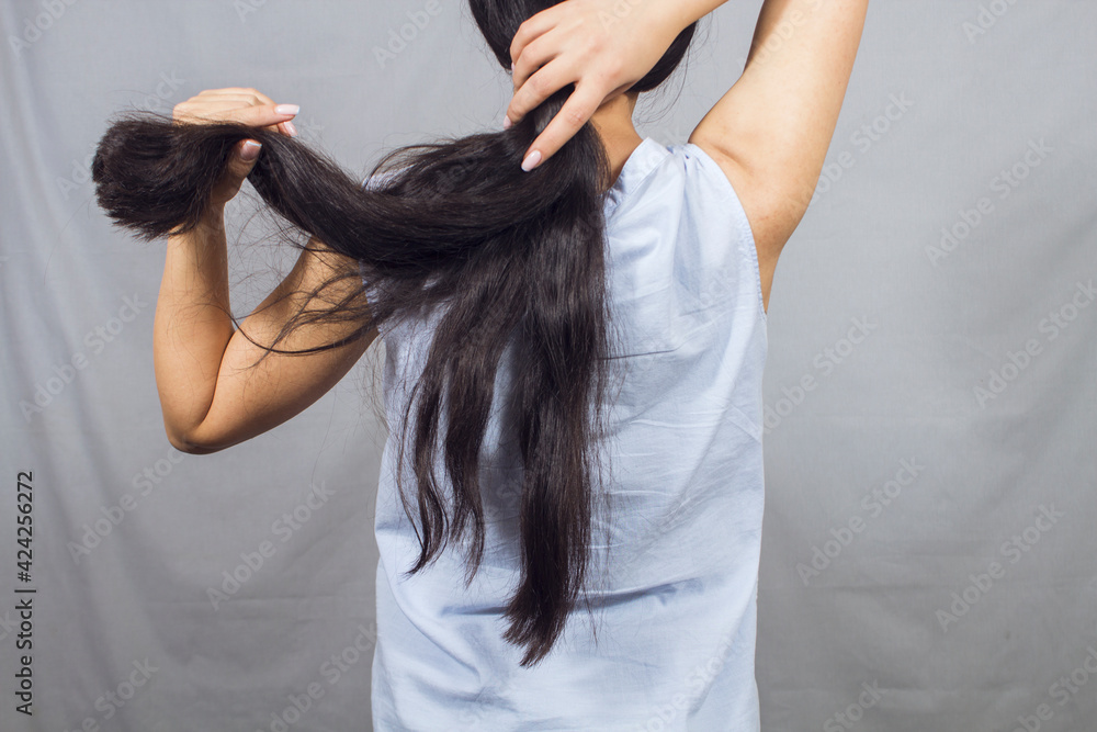 Fototapeta premium the girl straightens her hair