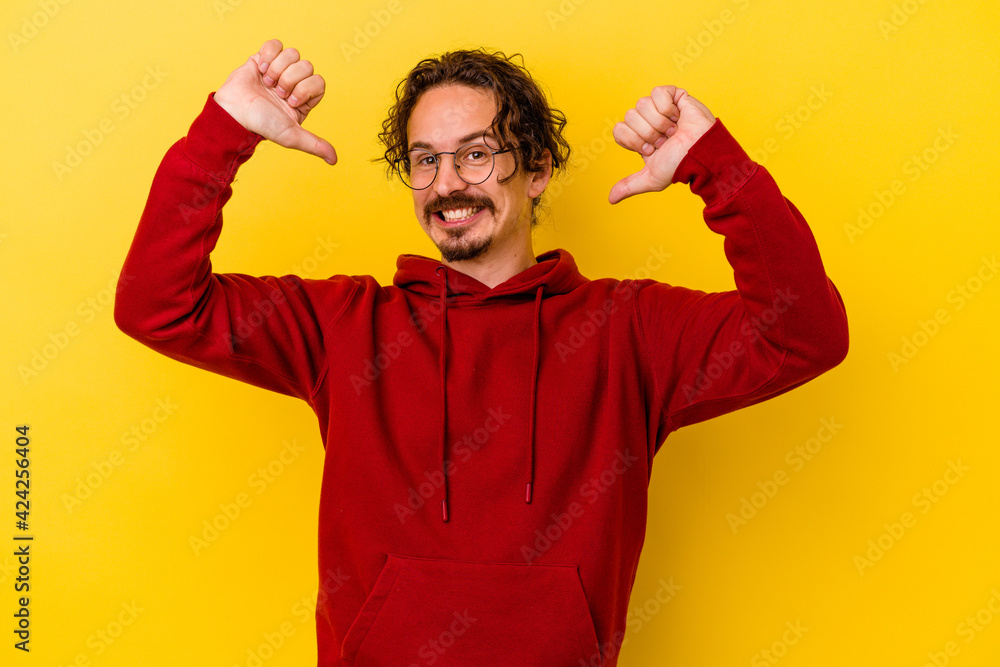 Young caucasian man isolated on yellow background feels proud and self confident, example to follow. Young caucasian man isolated on yellow background feels proud and self confident, example to follow.