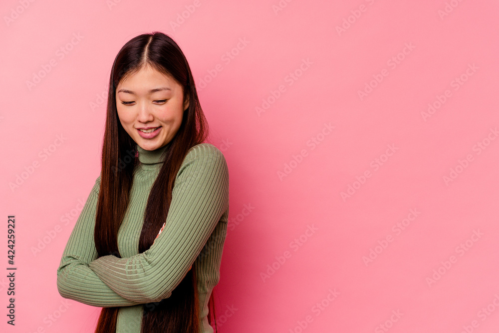Fototapeta premium Young chinese woman isolated on pink background smiling confident with crossed arms.