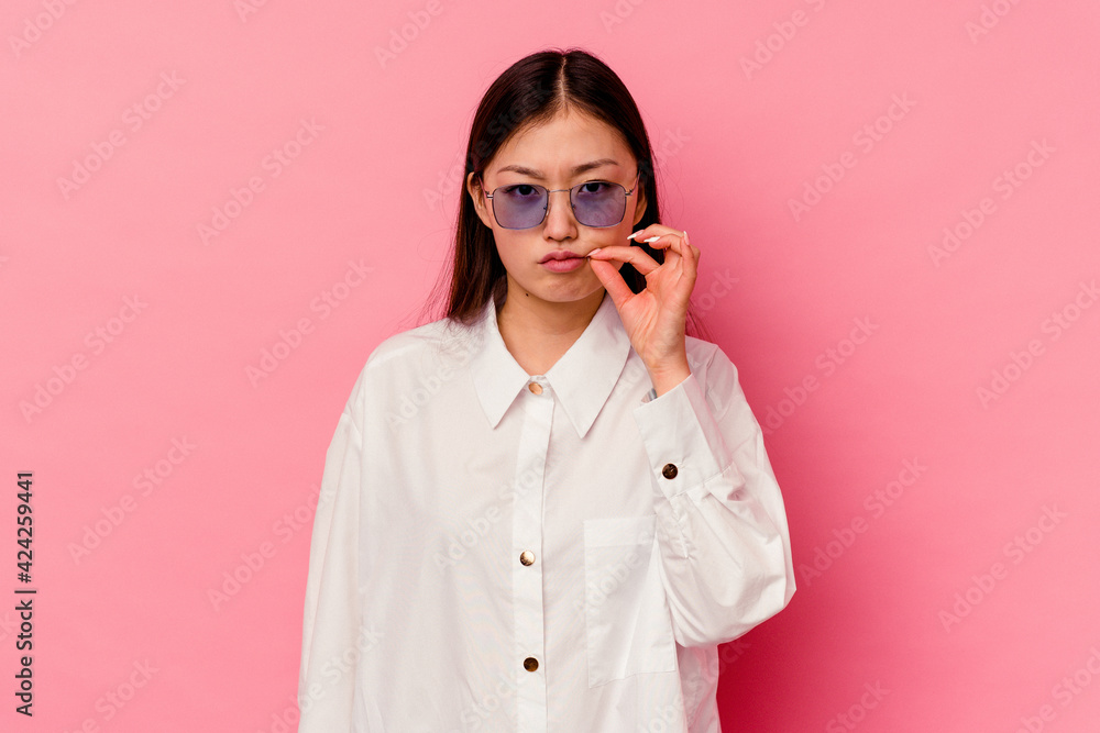Young chinese woman isolated on pink background with fingers on lips keeping a secret. Young chinese woman isolated on pink background with fingers on lips keeping a secret.