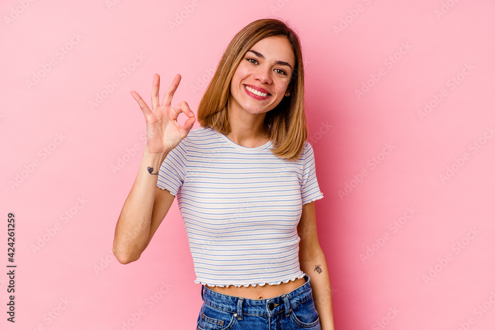 Young caucasian woman isolated on pink background cheerful and confident showing ok gesture. Young caucasian woman isolated on pink background cheerful and confident showing ok gesture.