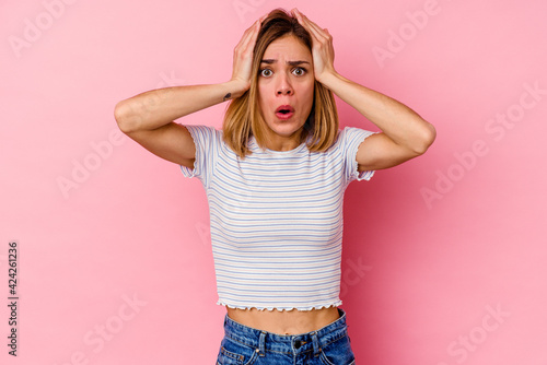 Young caucasian woman isolated on pink background being shocked, she has remembered important meeting.