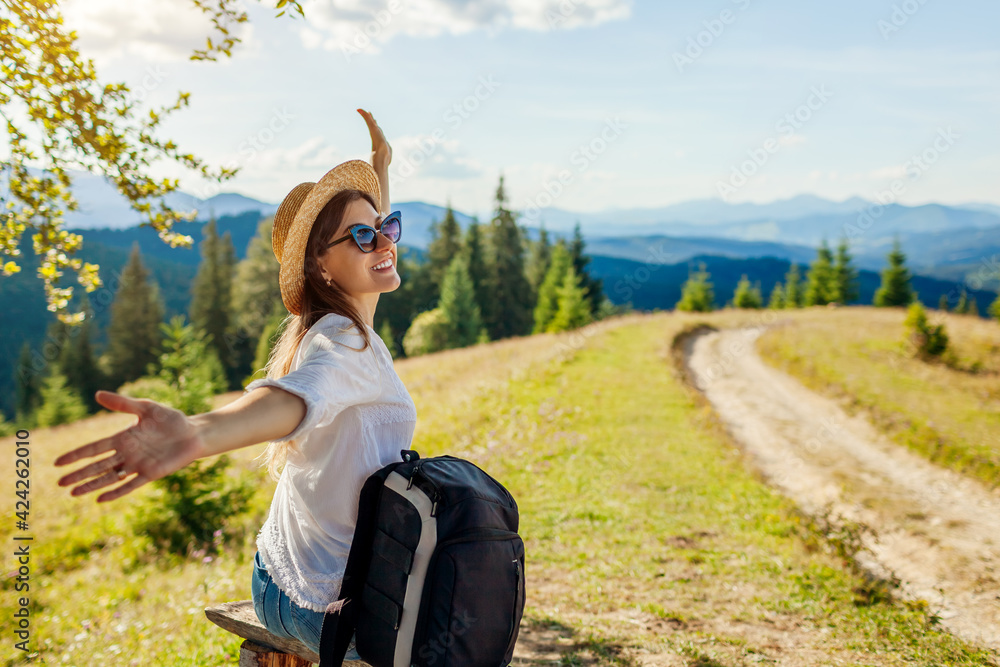 Trip to Carpathian mountains. Woman hiker relaxing admiring landscape with arms raised. Traveling in summer Ukraine - obrazy, fototapety, plakaty 