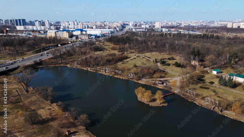 Flight over the city park. The lake and the island are visible. Spring in the city.