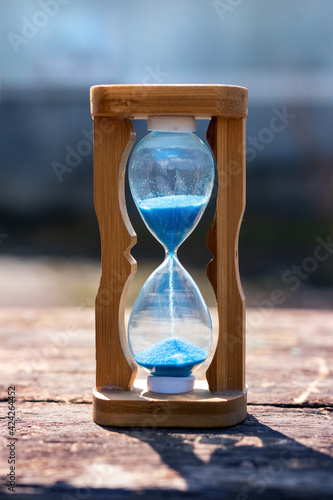 Hourglass on a wooden table in sunny weather