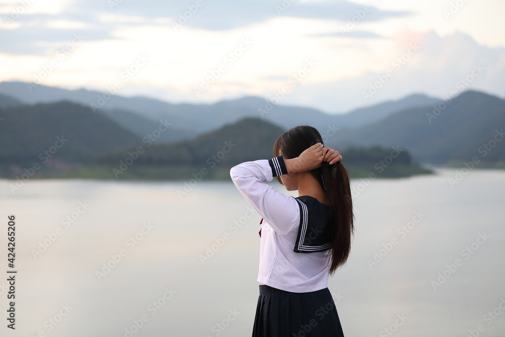 Asian school girl looking mountain with river in sunrise Asian school girl looking mountain with river in sunrise
