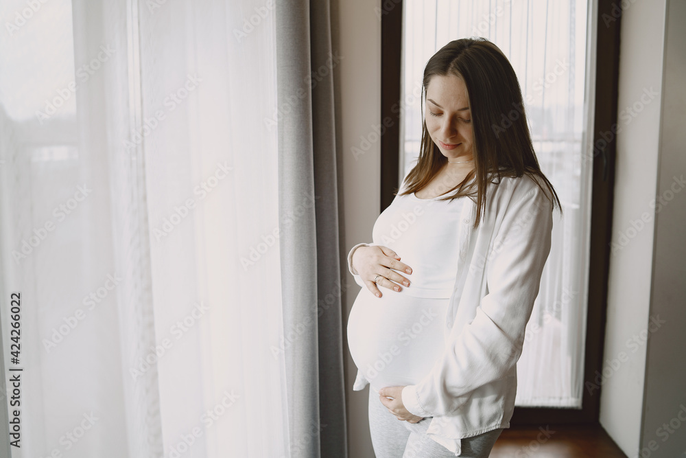 Pregnant woman hugging belly in anticipation of baby Pregnant woman hugging belly in anticipation of baby