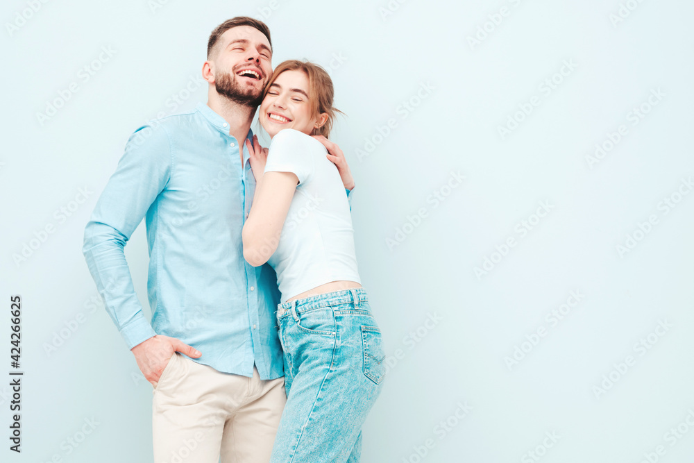 Smiling beautiful woman and her handsome boyfriend. Happy cheerful family having tender moments near light blue wall in studio.Pure cheerful models hugging.Embracing each other Smiling beautiful woman and her handsome boyfriend. Happy cheerful family having tender moments near light blue wall in studio.Pure cheerful models hugging.Embracing each other