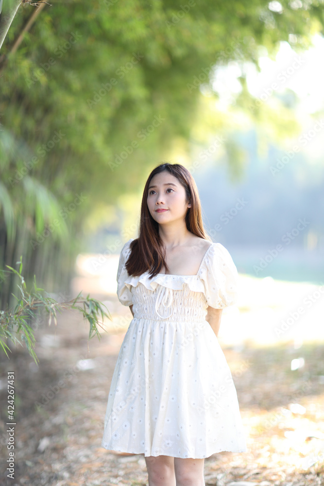 Beautiful young woman with white dress on bamboo forest background Beautiful young woman with white dress on bamboo forest background