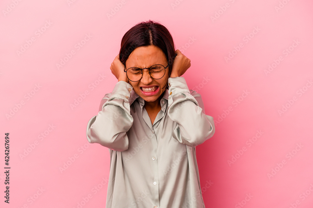 Young mixed race woman isolated on pink background covering ears with hands. Young mixed race woman isolated on pink background covering ears with hands.