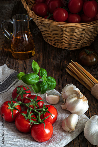 Italian food background with tomatoes, basil, spaghetti, olives, garlic.