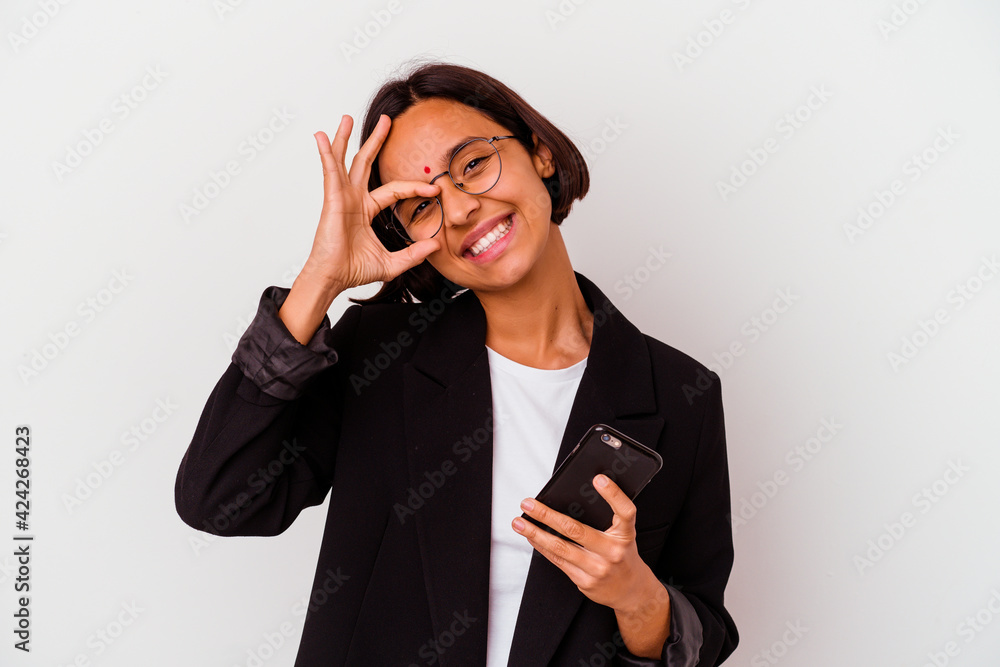 Young indian business woman holding a phone isolated excited keeping ok gesture on eye. Young indian business woman holding a phone isolated excited keeping ok gesture on eye.