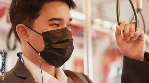 slow motion scene of middles eastern businessman hand holding handstrap handle in the public transport to go to work in the rush time (morning) for new normal lifestyle and transportation concept photo