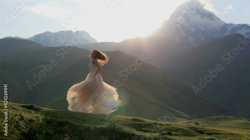 Beautiful girl dances in the evening against the backdrop of the mountains. Slow motion. Beautiful princess
