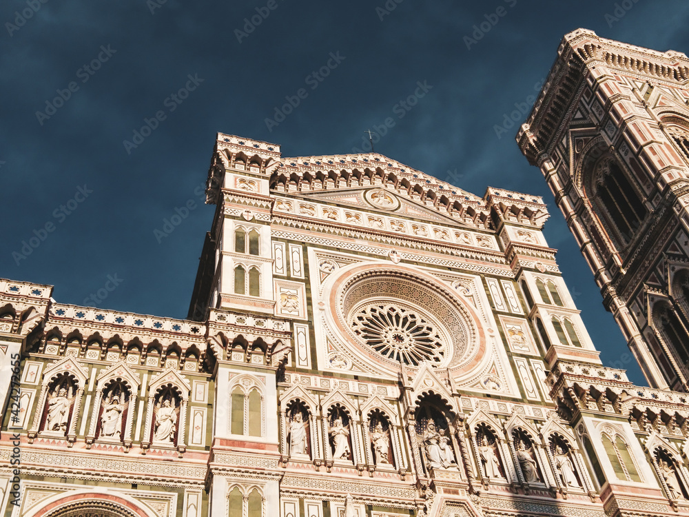 Cathedral of Santa Maria del Fiore. Landmark 1200s cathedral colored marble facade close sunny view with blue sky background. Travel Italy. Color graded