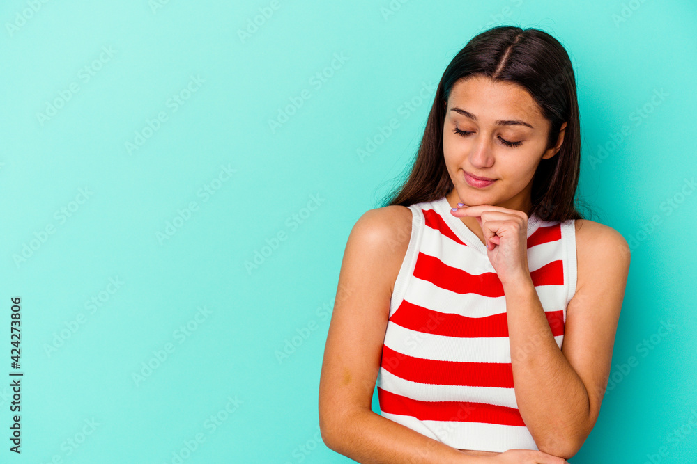 Young Indian woman isolated on blue background looking sideways with doubtful and skeptical expression. Young Indian woman isolated on blue background looking sideways with doubtful and skeptical expression.