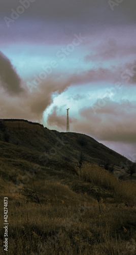 Strangely colored sky and clay mountain with grass