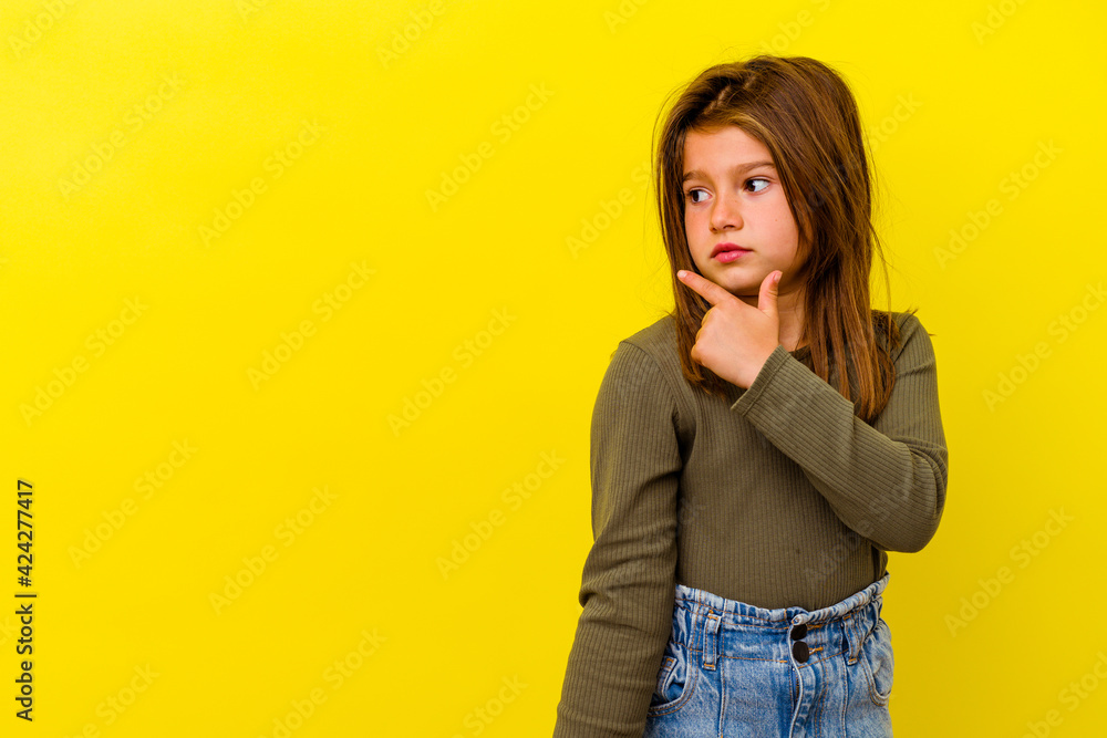 Little caucasian girl isolated on yellow background pointing to the side Little caucasian girl isolated on yellow background pointing to the side