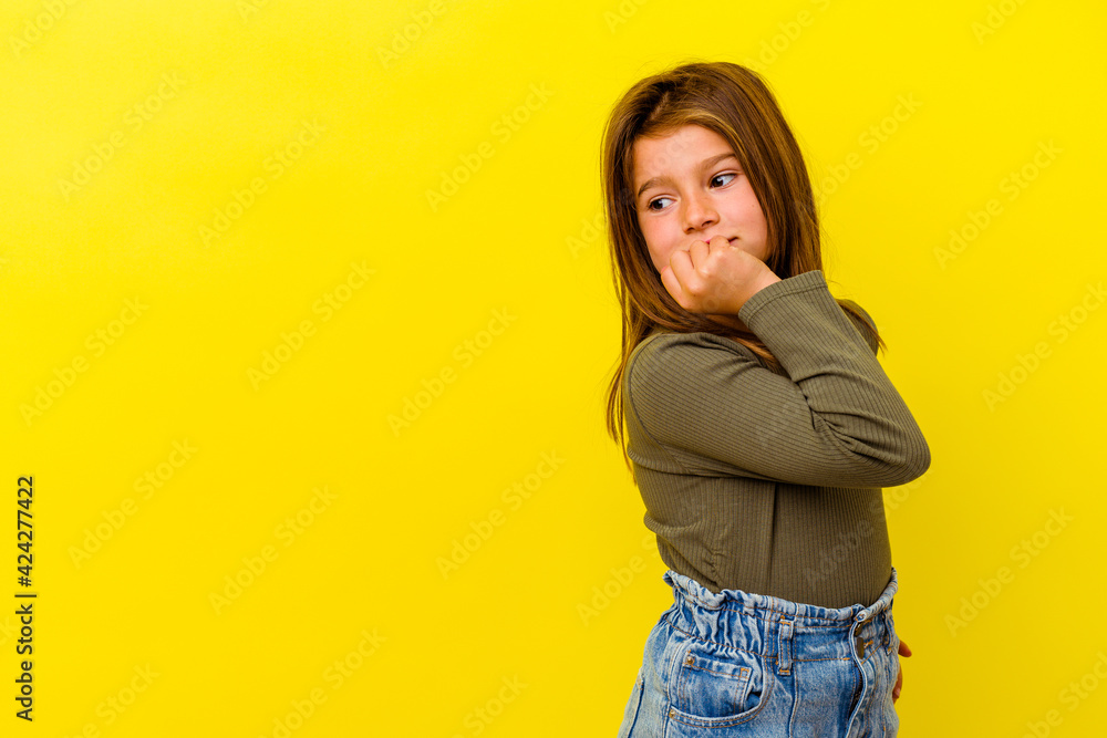 Little caucasian girl isolated on yellow background relaxed thinking about something looking at a copy space. Little caucasian girl isolated on yellow background relaxed thinking about something looking at a copy space.