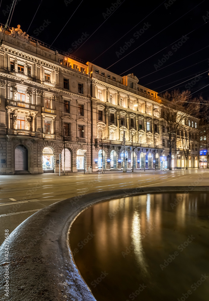 Historic buildings and reflection in a water of a fountain on the Bahnhofstrasse in Zurich, Switzerland