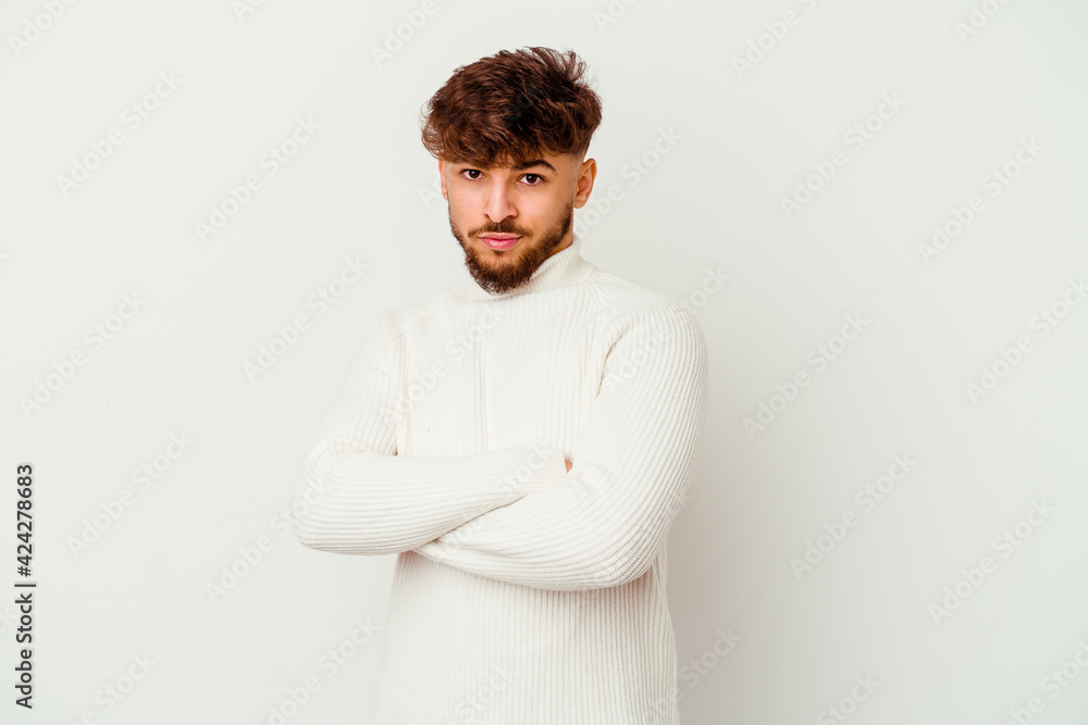 Young Moroccan man isolated on white background frowning face in displeasure, keeps arms folded. Young Moroccan man isolated on white background frowning face in displeasure, keeps arms folded.