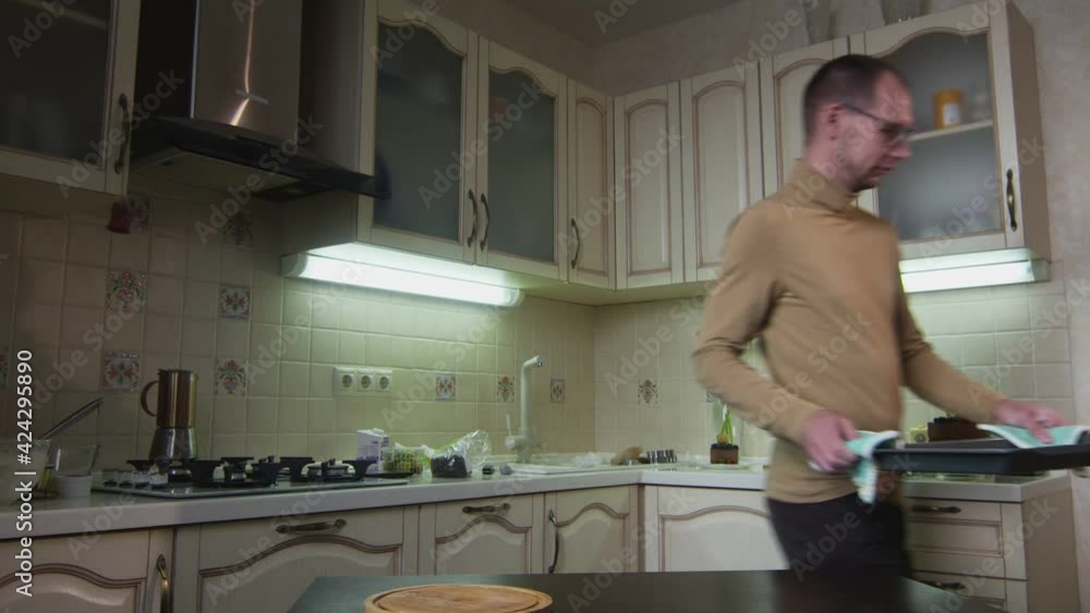 Male chef man puts gingerbread cookies on table at kitchen in the oven Male chef man puts gingerbread cookies on table at kitchen in the oven