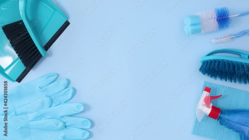 Household cleaning tools and sanitary on left and right side of pastel blue background. Stop motion Household cleaning tools and sanitary on left and right side of pastel blue background. Stop motion
