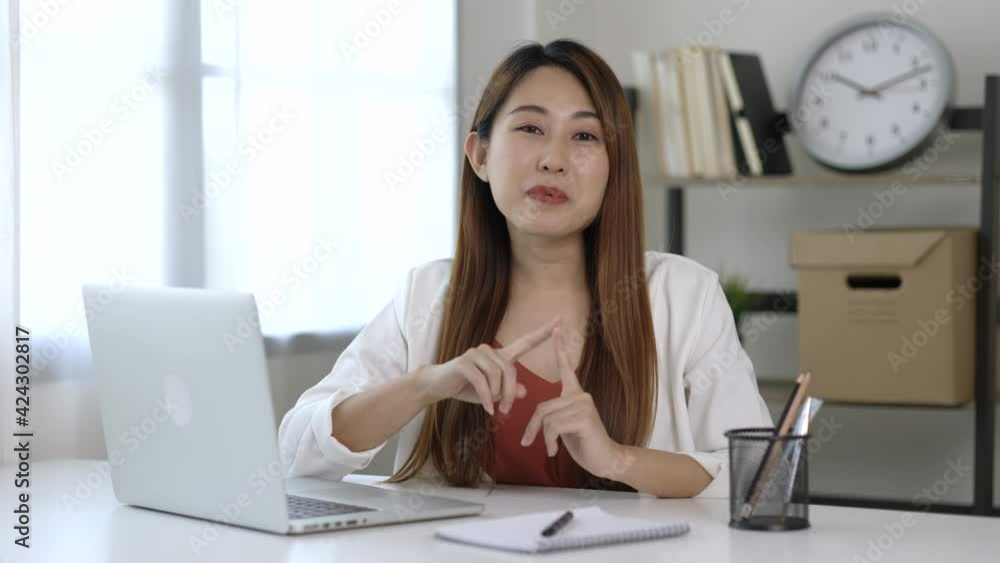 Young asian business woman working with laptop conferencing with business team looking at camera. Business female support operator with computer in office. Young asian business woman working with laptop conferencing with business team looking at camera. Business female support operator with computer in office.