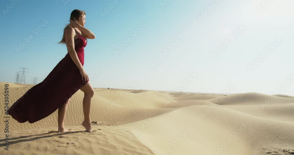 Model in red dress is posing in the Great Sandy Desert of Dubai, UAE, vacation Model in red dress is posing in the Great Sandy Desert of Dubai, UAE, vacation