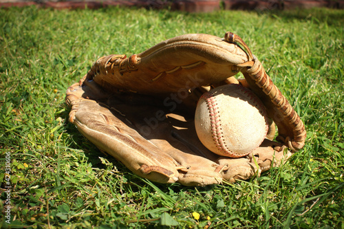 Baseball in glove on outfield grass