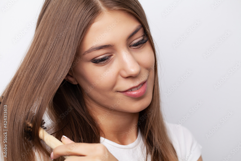 Young beautiful woman combing her hair in living room Young beautiful woman combing her hair in living room