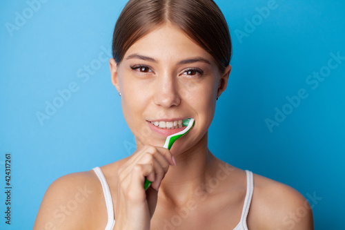 Wallpaper Mural Young woman brushing her teeth on blue background Torontodigital.ca