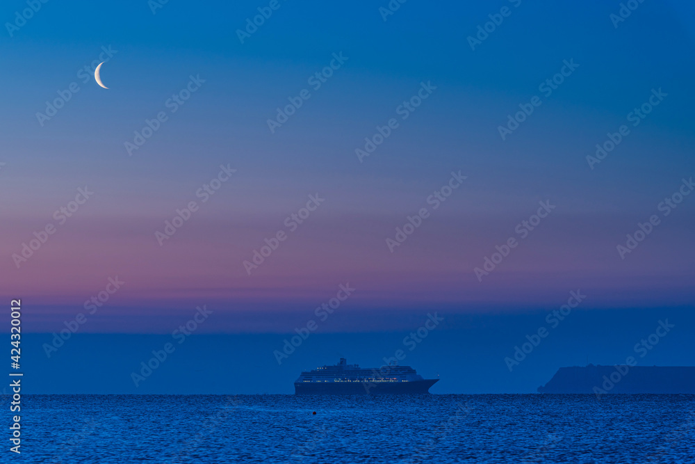 View of Cruise ferry and moon during the blue hour in Torquay, Devon, England, Europe