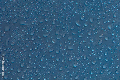 Abstract water drops texture. Wet raindrops on glass blue background. Bubble pattern.