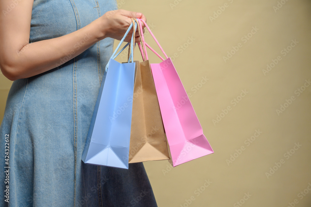 Young happy summer shopping woman with shopping bags isolated on grey background