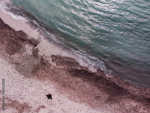 Toma de drone en la playa de mujer con pareo photo