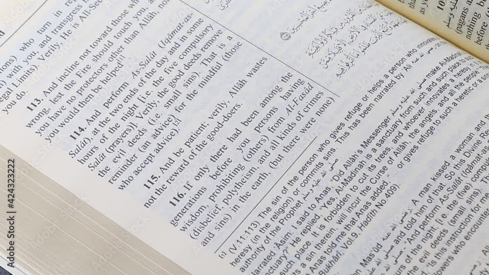 Flipping through the pages of the Quran in Arabic with English translation. Flipping through the pages of the Quran in Arabic with English translation.