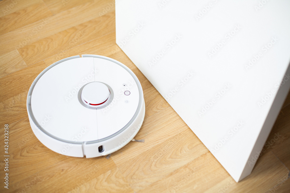 Vacuum cleaner robot runs on wood floor in a office Vacuum cleaner robot runs on wood floor in a office