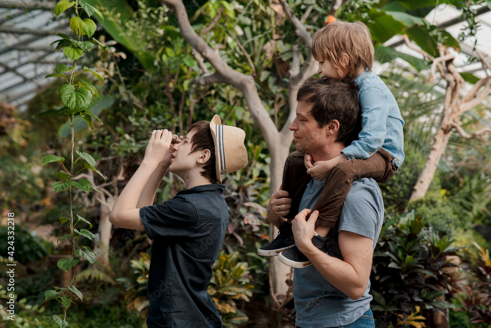 Adventurous family inspecting tropical gallery in Botanical garden. Local travel