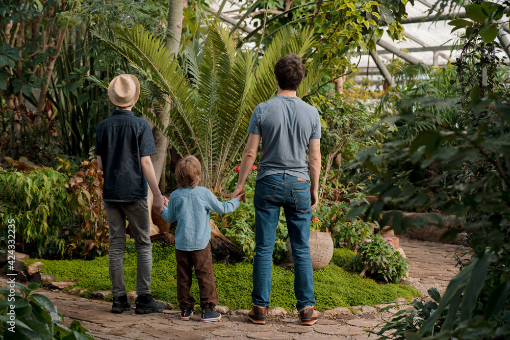 Adventurous family inspecting tropical gallery in Botanical garden. Local travel Adventurous family inspecting tropical gallery in Botanical garden. Local travel