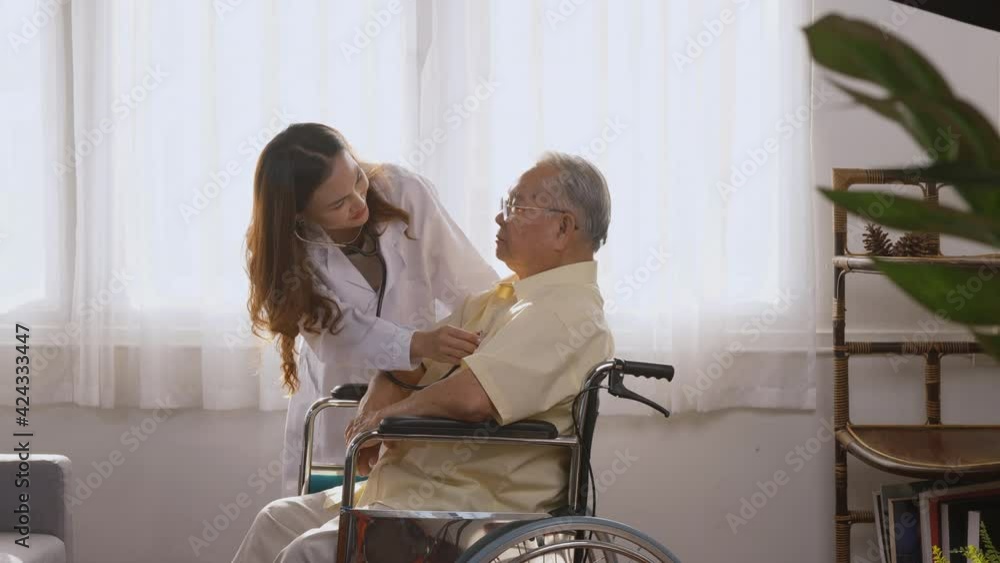 Female nurse doctor wear white uniform cardiologist examining patient senior or elderly old man during sit on wheelchair listening checking heartbeat using stethoscope at home, Health visitor concept Female nurse doctor wear white uniform cardiologist examining patient senior or elderly old man during sit on wheelchair listening checking heartbeat using stethoscope at home, Health visitor concept