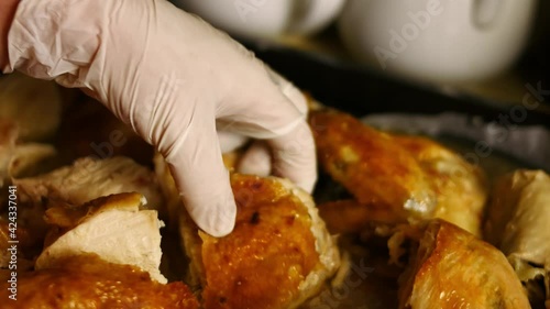 Adding carved big oven roasted chicken to spiced sauce in a frying pan. Process of cooking shkmeruli - Georgian dish. Artistic shooting photo