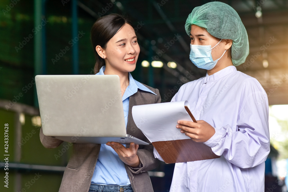 Asian women smiling use laptop explain employee , Manager computer training employee in food factory Asian women smiling use laptop explain employee , Manager computer training employee in food factory