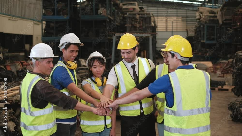 A group of people in uniforms and helmets in warehouse: Workers of Various races such as Caucasian, Black, and Asian are factory employees and colleagues collaborating and harmony in company. A group of people in uniforms and helmets in warehouse: Workers of Various races such as Caucasian, Black, and Asian are factory employees and colleagues collaborating and harmony in company.