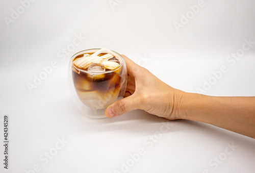 Hand holding iced coconut coffee in double walls glass isolated on white background.